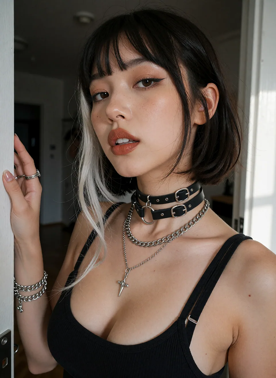 Dark-haired woman wearing a black top and silver necklaces.
